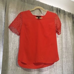 Red t-shirt with a mesh floral design sleeve.